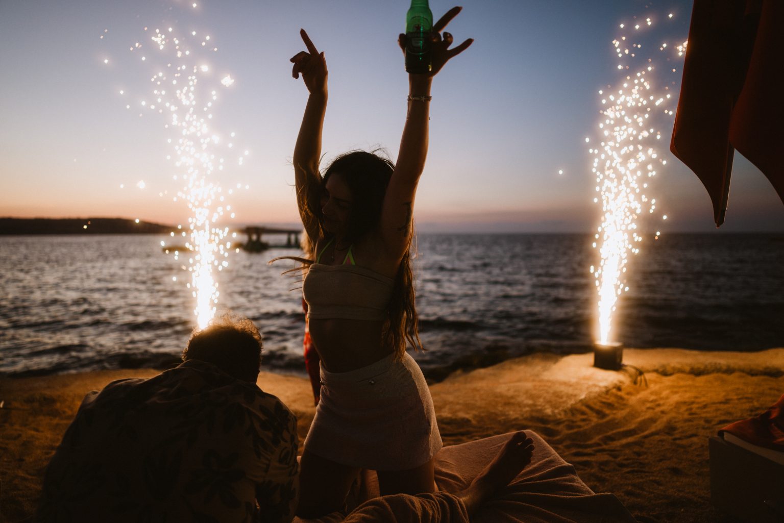 Woman dancing in front of fireworks